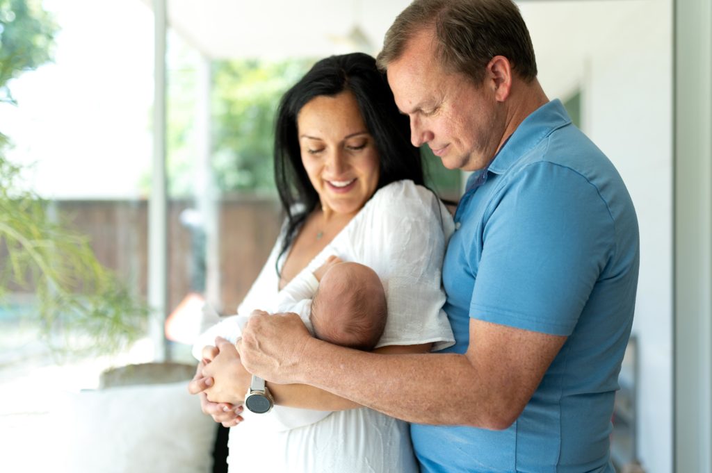 Parents holding newborn in newborn in home photography session