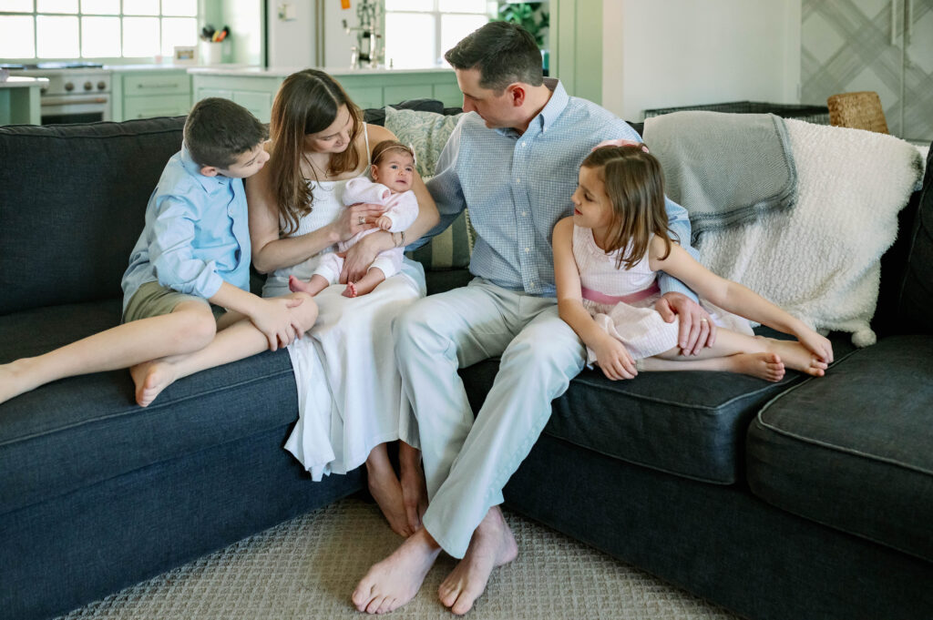 family sitting on the sofa enjoying newborn