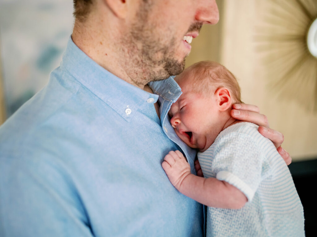 dad cradles newborn yawning 