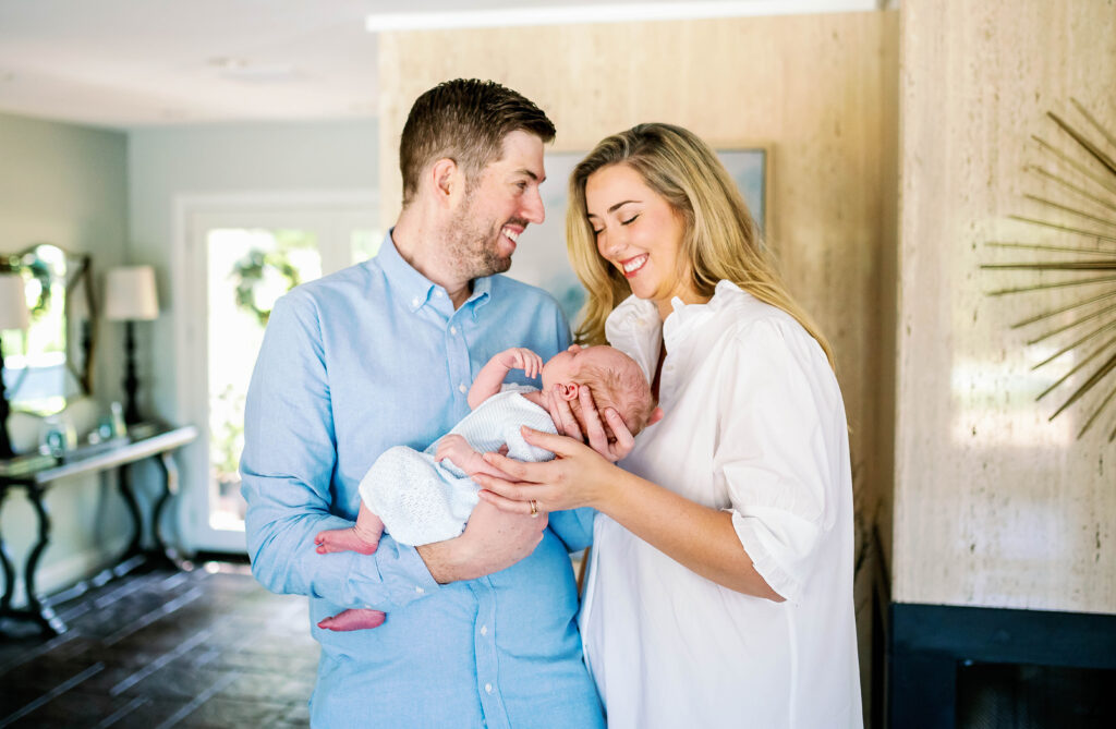 new parents hold their young son