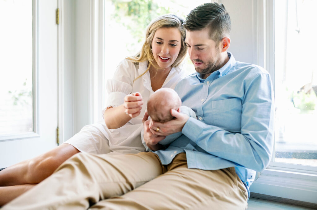 parents holding newborn baby in home