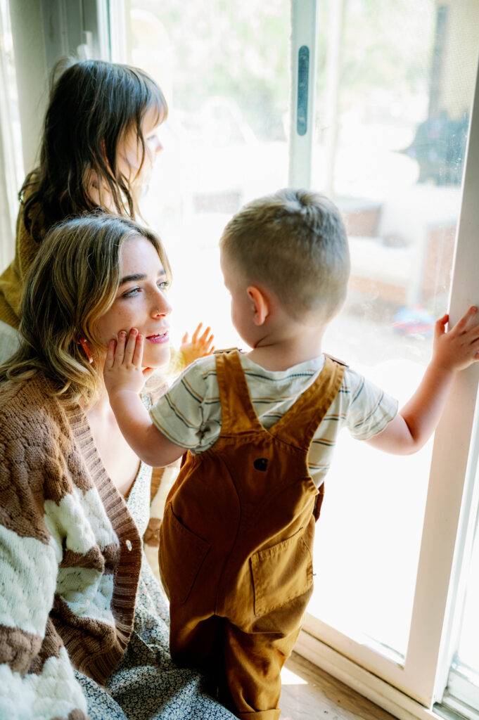 Children looking out window and mom watching