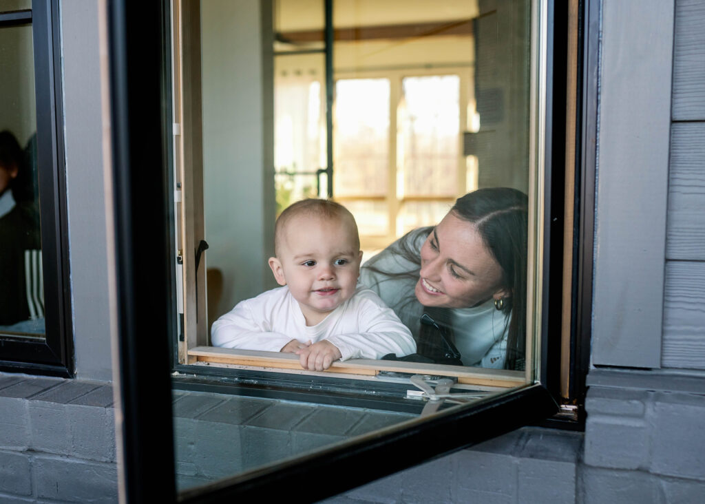 mom looking out window with toddler