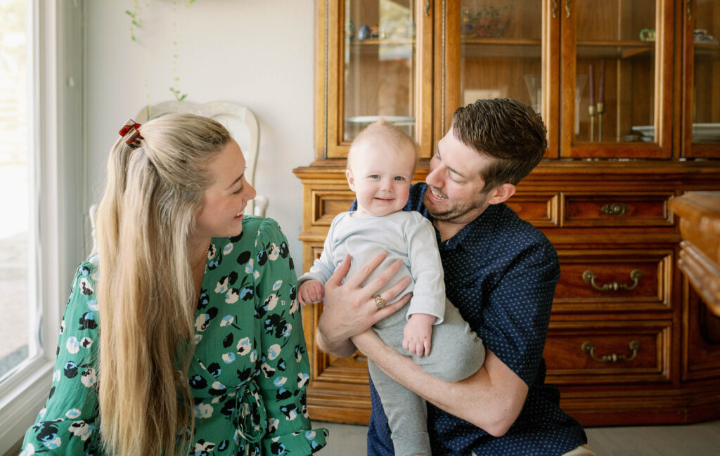 mom and dad playing with baby at milestone session