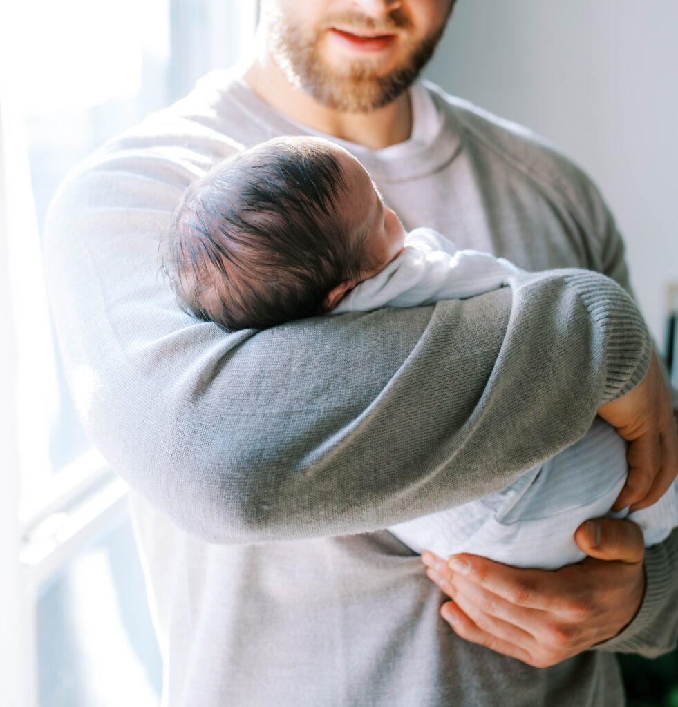 dad cradling newborn