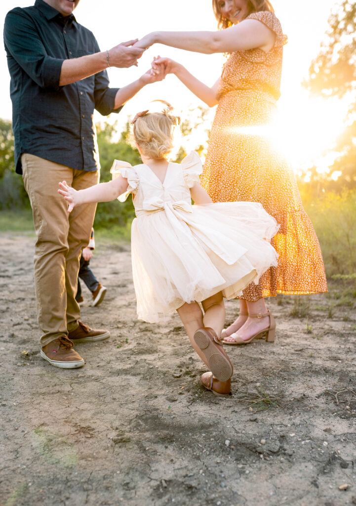 Daughter playing a game during an outdoor mini session during fall family photo mini sessions.