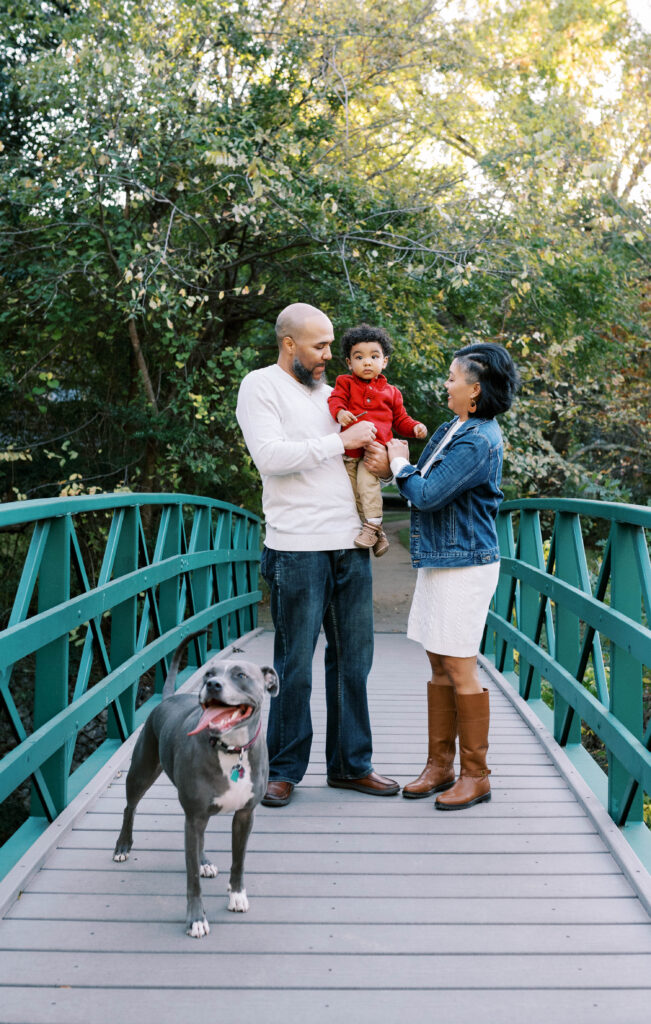 A young family standing on bridge for fall mini session.