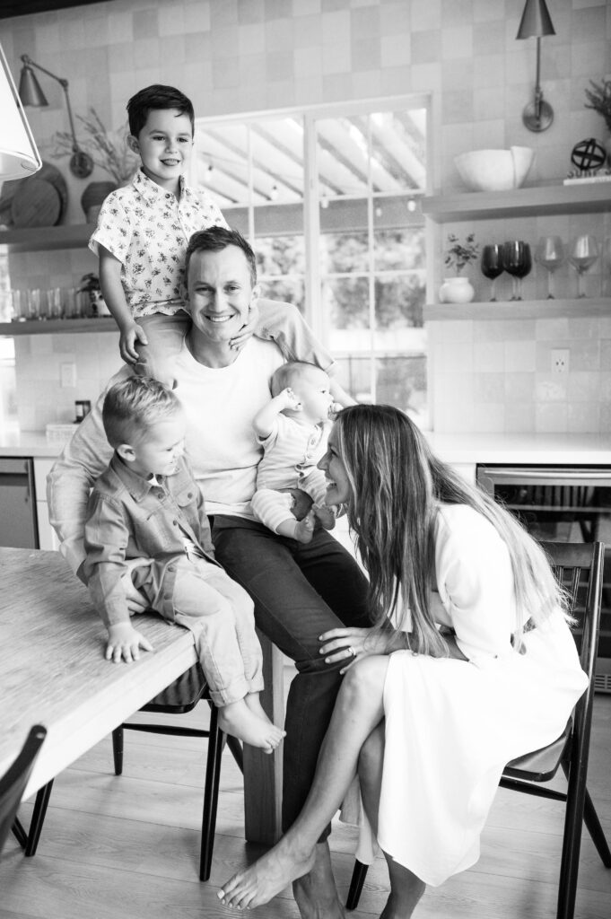 family playing with children in kitchen during newborn session