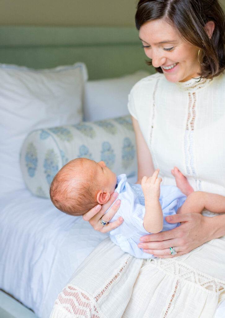 mom holding newborn in DFW home during photo session
