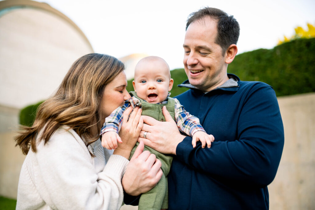 Mom and dad holding infant son during Fort Worth fall mini sessions with Allison Krogness Photography.
