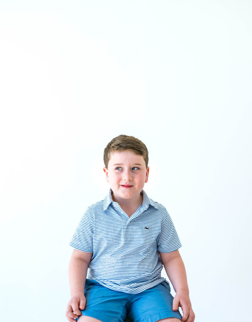 Young boy sitting and looking to the side during a Fort Worth child photography session with Allison Krogness at the Lumen Room in Fort Worth.
