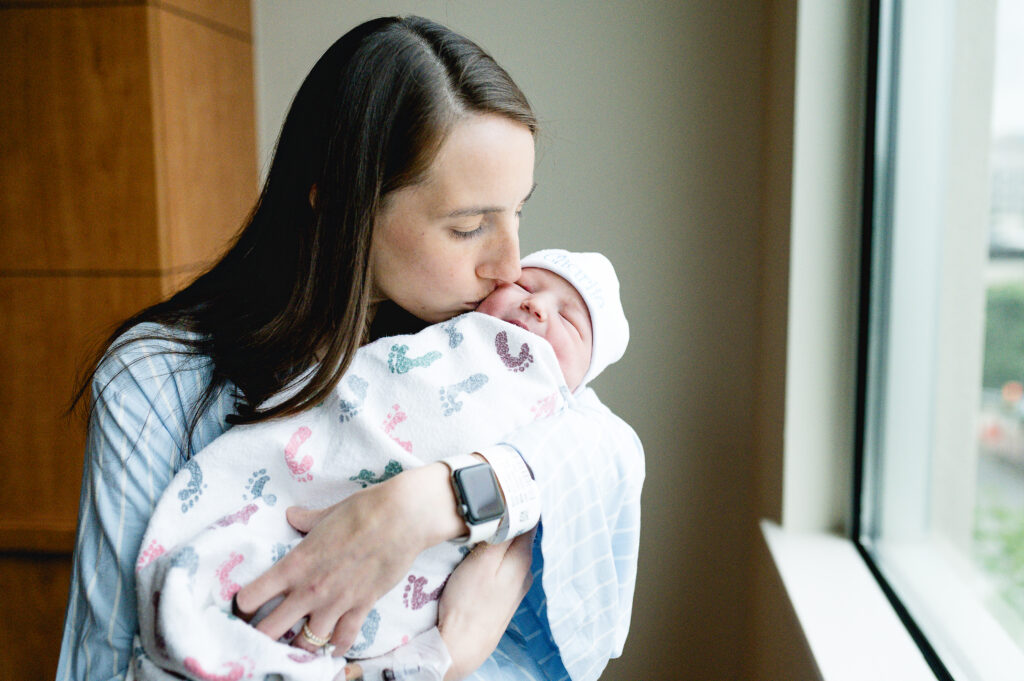 Fresh 48 session in Fort Worth — mom holding newborn in soft hospital light.