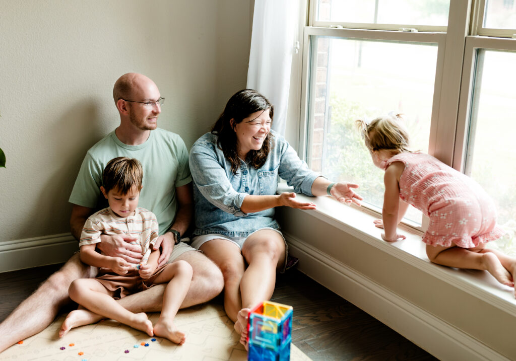 Fort Worth candid photographer Allison Krogness captures a family in their playroom playing with toys on the floor.

