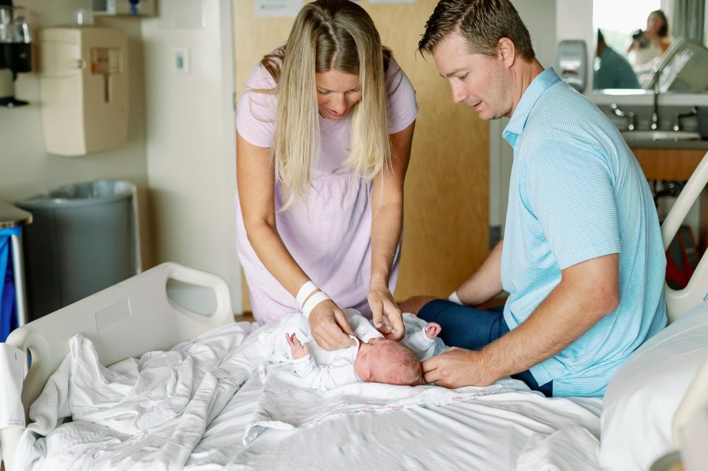 parents dressing newborn in hosiptal
