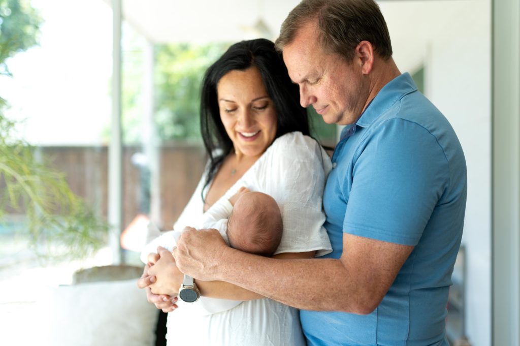 Parents holding newborn in newborn in home photography session
