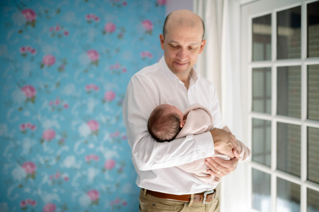 dad holding newborn during in home photo session