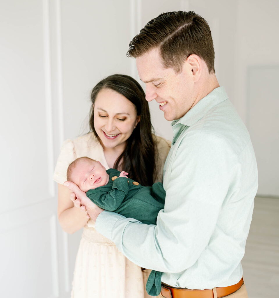 mom and dad holding newborn baby
