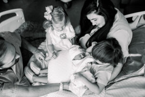 mom and older siblings with newborn